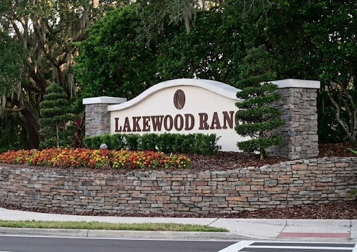 Lakewood Ranch entrance sign with landscaped flower beds and greenery, representing the community's vibrant atmosphere for part-time residents.
